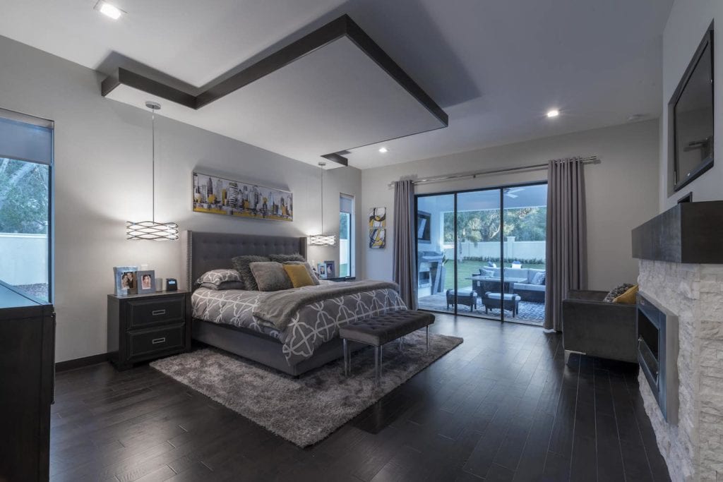Master bedroom with a floating ceiling canopy over the bed and hanging light pendants in this Florida Modern Home designed and built by Orlando Custom Home Builder Jorge Ulibarri www.imyourbuilder.com