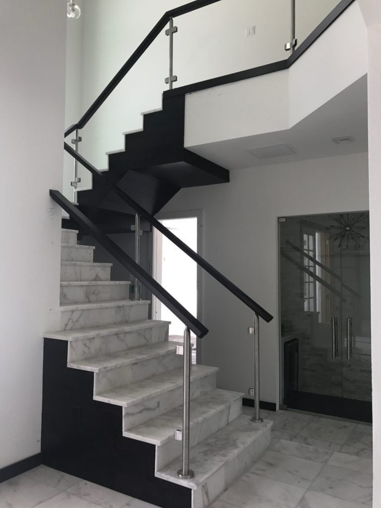 This staircase blends the natural materials of marble and wood with glass and chrome for a perfect balance of warmth with sleek elements. The staircase was designed by Orlando Custom Home Builder Jorge Ulibarri in this Florida Modern home under construction in Lake Mary. www.imyourbuilder.com 
