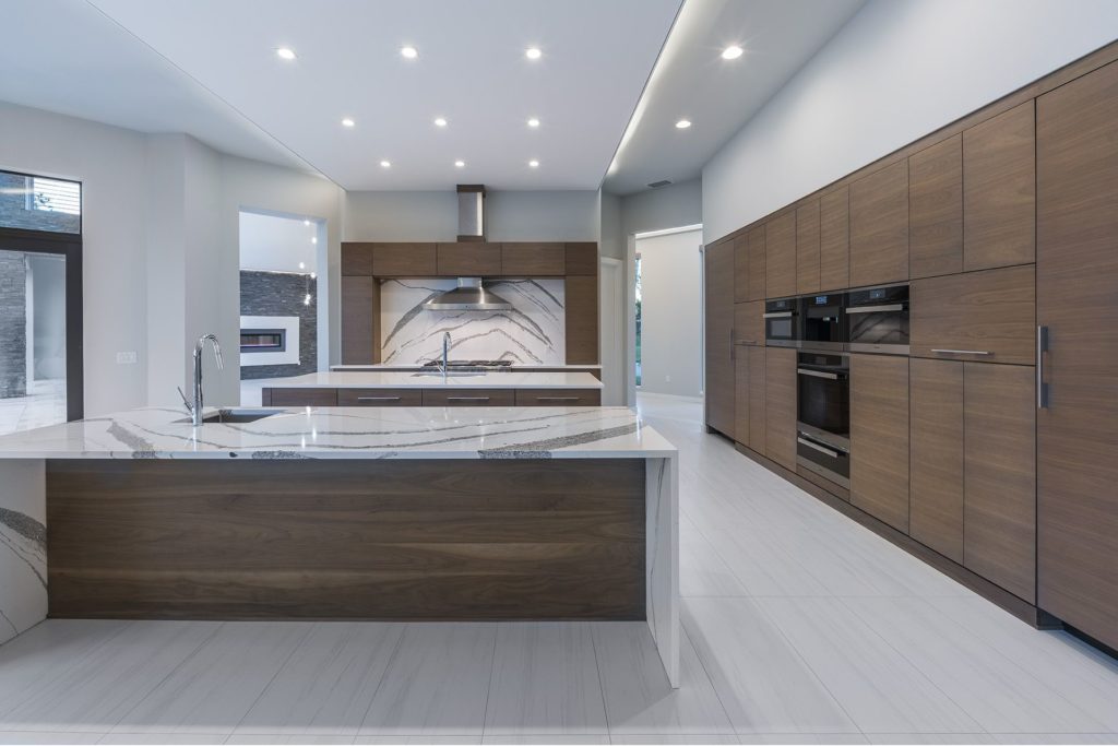 Contemporary kitchen well-appointed with two islands with quartz countertops in this Florida Modern home by Orlando Custom Homebuilder Jorge Ulibarri
