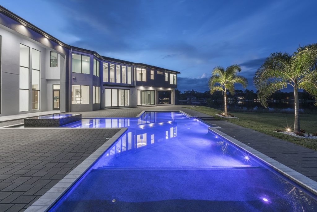 This Florida Modern custom home by Orlando Custom Homebuilder Jorge Ulibarri brings the outside in by featuring sliding glass walls erasing separation between indoor and outdoor living, embracing Florida’s climate and lifestyle year-round.