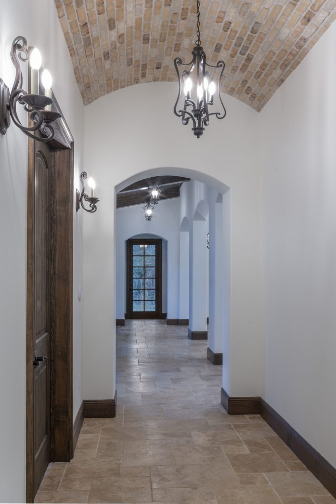 Interior hallway with arches that open to the great room in this Spanish Revival custom home by Orlando Custom Homebuilder Jorge Ulibarri. 
