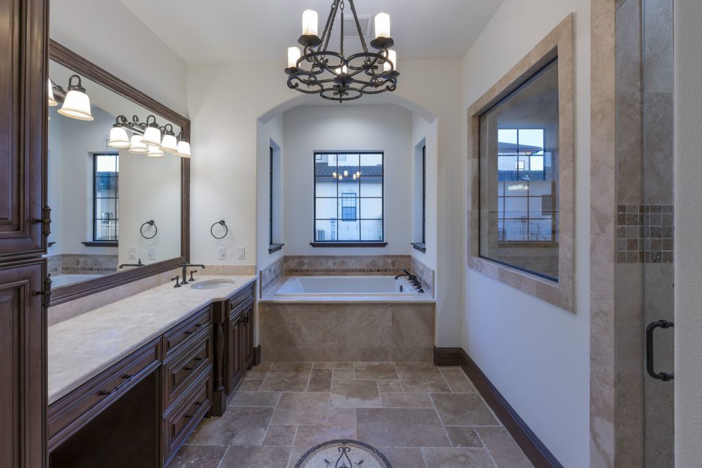 The master bath is clad in travertine stone that compliments the home's flooring.