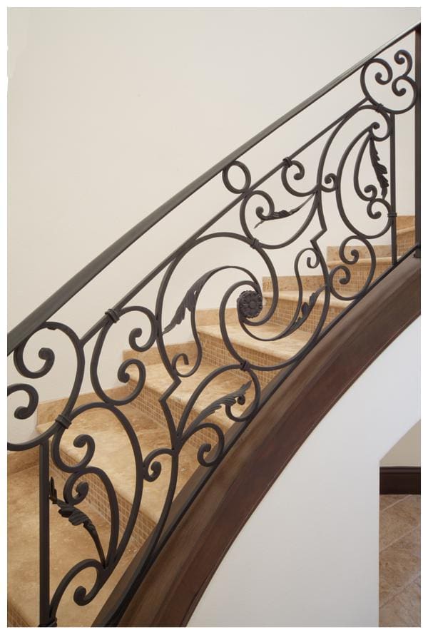 Intricate scrollwork on the staircase frames the travertine stair treads embellished with stone mosaics in Villa Hernandez, a home designed and built by Orlando Custom Home Builder Jorge Ulibarri. For more go to www.imyourbuilder.com